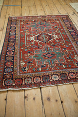 Vintage Karaja rug seen from an angle, showcasing the triple medallion design on a cherry red field.