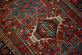 Geometric hook and latch medallion and serpent border on a vintage Persian Karaja rug.