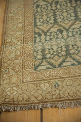 Textured pile and knot heads on the corner of a vintage Malayer rug with a coffee brown border.