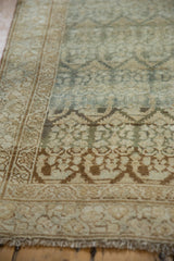 Angled close-up of the vintage Malayer's boteh-patterned border and intact selvage.