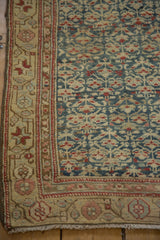Distressed pile of a Kurdish Hamadan rug corner, with blue, red plant motifs and fringe.