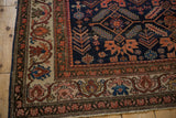 Antique Malayer rug corner showing the ivory border with stylized vines and lotus flowers.