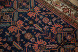 Corner detail of an antique Malayer rug with an ivory vine border and a sapphire blue geometric field.