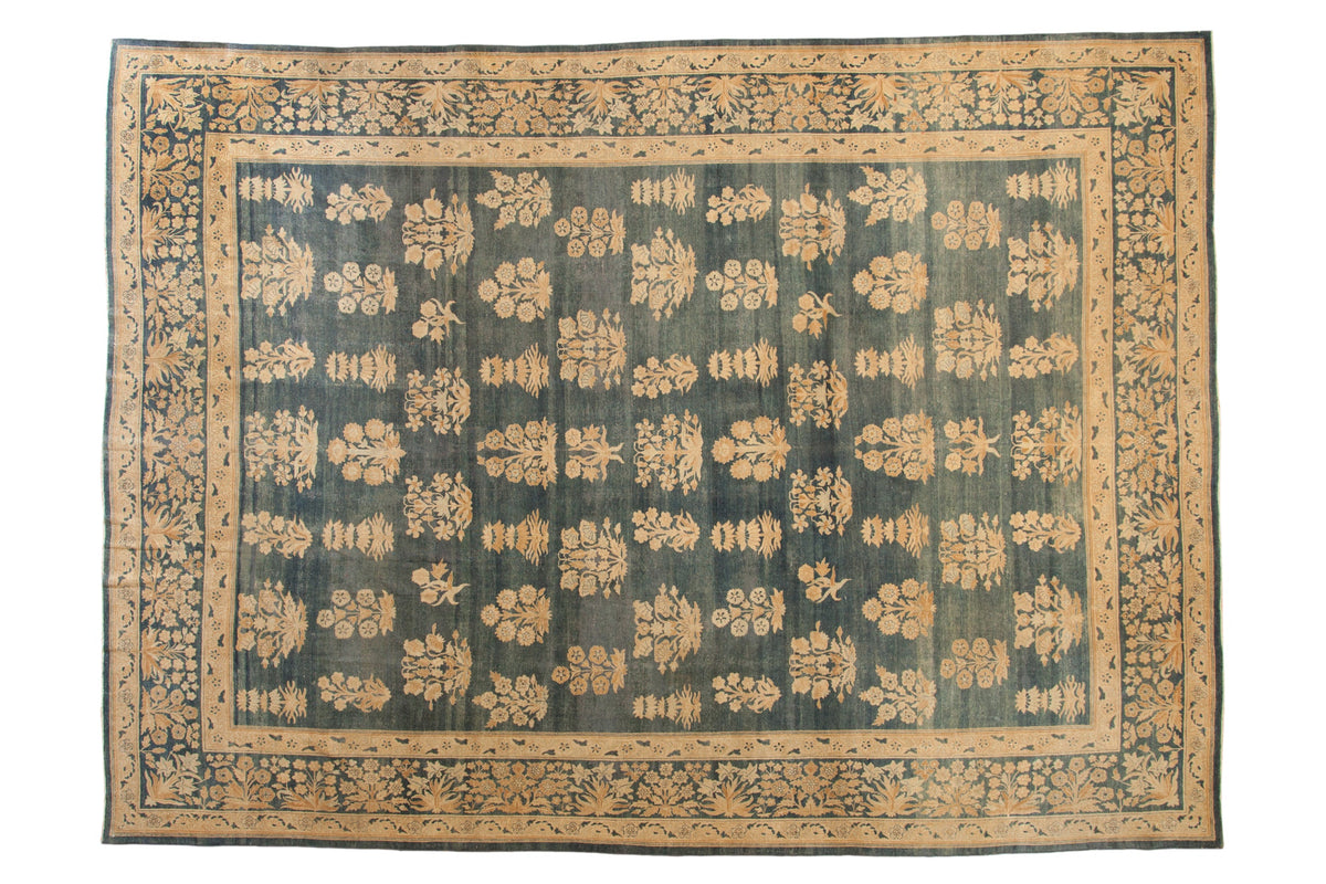 Distressed antique Kerman carpet, allover floral bouquets on abrashed blue, with millefleur border.
