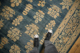 Distressed indigo Kerman rug's abrashed field showing floral bouquets and millefleur border.
