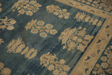 Antique distressed Kerman carpet's abrashed blue field with floral bouquets and millefleur border.