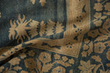 Distressed Kerman rug close-up: abrash, beige floral motifs, and border on denim blue.