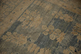 Close-up of antique Kerman carpet's distressed floral pattern and abrashed denim blue ground.