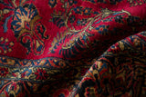 A draped view showing the plush, hand-knotted texture of a vintage Sarouk carpet's floral pattern.