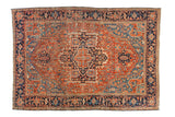Antique Heriz carpet with a concentric medallion and Turtle Samovar border in brick red and navy blue tones.