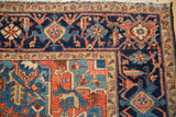 An antique Heriz carpet corner with its Turtle Samovar border and wear to the knot heads.