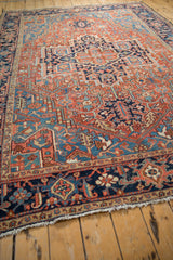 Low-angle view across an antique Heriz carpet showing its time-softened texture and geometric design.