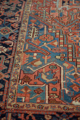 Low-pile texture on the navy Turtle Samovar border and brick red geometric field of an antique Heriz.
