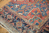 Corner view of an antique Heriz carpet's navy Turtle Samovar border and visible knot head texture.
