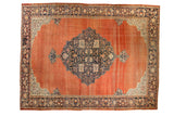 Antique Farahan Sarouk carpet with a navy floral medallion on an abrashed terracotta field with detailed ivory corner spandrels.