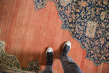 Abrashed terracotta field and low-pile texture of an antique Farahan Sarouk carpet.