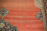Abrashed terracotta field with detailed floral corner spandrels on an antique Farahan Sarouk carpet.