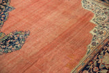 Abrashed terracotta field and scrolling florals in the ivory corner spandrel of a Farahan Sarouk.