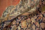 Supple drape of an antique Farahan Sarouk carpet with terracotta, ivory, and navy blue floral motifs.