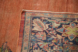 Supple, terracotta-colored foundation of a hand-knotted Farahan Sarouk carpet, revealed at the corner.