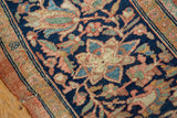 Scrolling floral arabesques and border detail on a hand-knotted antique Farahan Sarouk carpet.