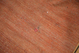 A small historic repair on the supple, terracotta-hued foundation of the antique Persian rug.