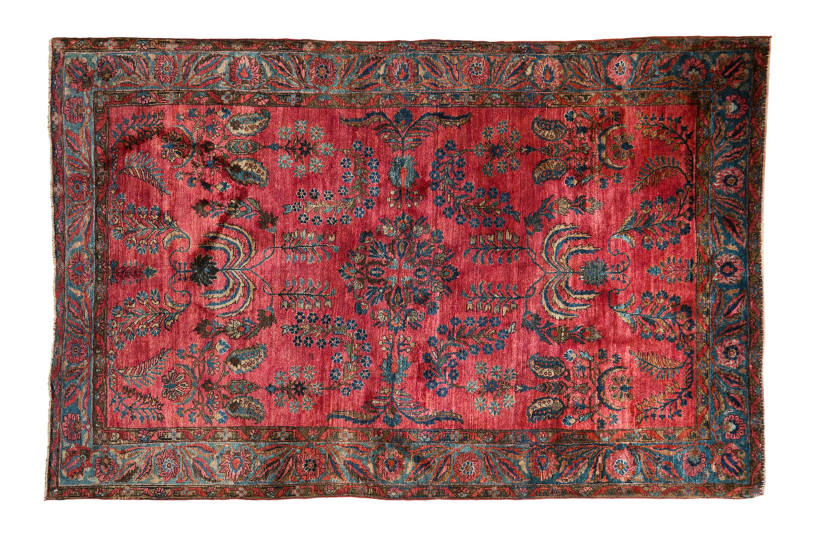 Antique Mohajeran Sarouk rug with weeping willow and floral motifs on an abrashed raspberry red field.