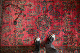 A perspective view showing the glossy wool pile and rich floral design of an antique Sarouk.