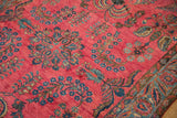 Glossy raspberry-red wool pile of an antique Sarouk with detailed blue floral vines.