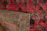 Persian Sarouk corner folded back, revealing its glossy wool pile and sturdy hand-knotted foundation.