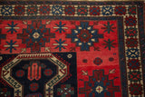 Close-up on the geometric gul border and stepped medallions of this antique Persian rug.