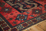 Low hand-knotted pile of an antique rug with stepped floral designs in sapphire blue and strawberry red.