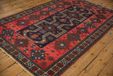 Angled perspective of an antique Persian rug's geometric floral gul and stepped outline.