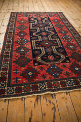 Angled view highlighting the even wear and geometric patterns of an antique Northwest Persian rug.