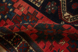 The supple hand-knotted pile of an antique Persian rug with geometric motifs in red and sapphire blue.