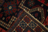 Corner of an antique Persian rug folded to show the dense, hand-knotted pile and foundation.