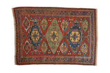 Antique Caucasian Soumac rug with three large diamond medallions in sapphire blue and jade green on a ruby red field.