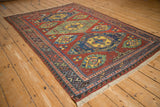 High-angle view of an antique Caucasian Soumac rug displaying its bold, geometric medallions and intricate borders.