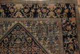 The wide main border of an antique Farahan Sarouk, showing splayed lotus flowers and time-softened pile.