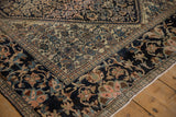 Corner of an antique Farahan Sarouk showing the wide navy border with oversized lotus flowers.