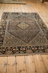 An antique Farahan Sarouk rug's full profile, showing the navy Herati field and complex lotus border.
