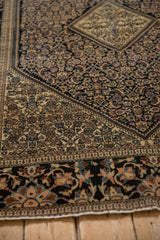 A Farahan Sarouk's corner contrasts the navy Herati field with a wide lotus flower border.
