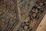 Close-up of an antique rug's corner showing the Herati field and splayed lotus flower border with mostly even wear.