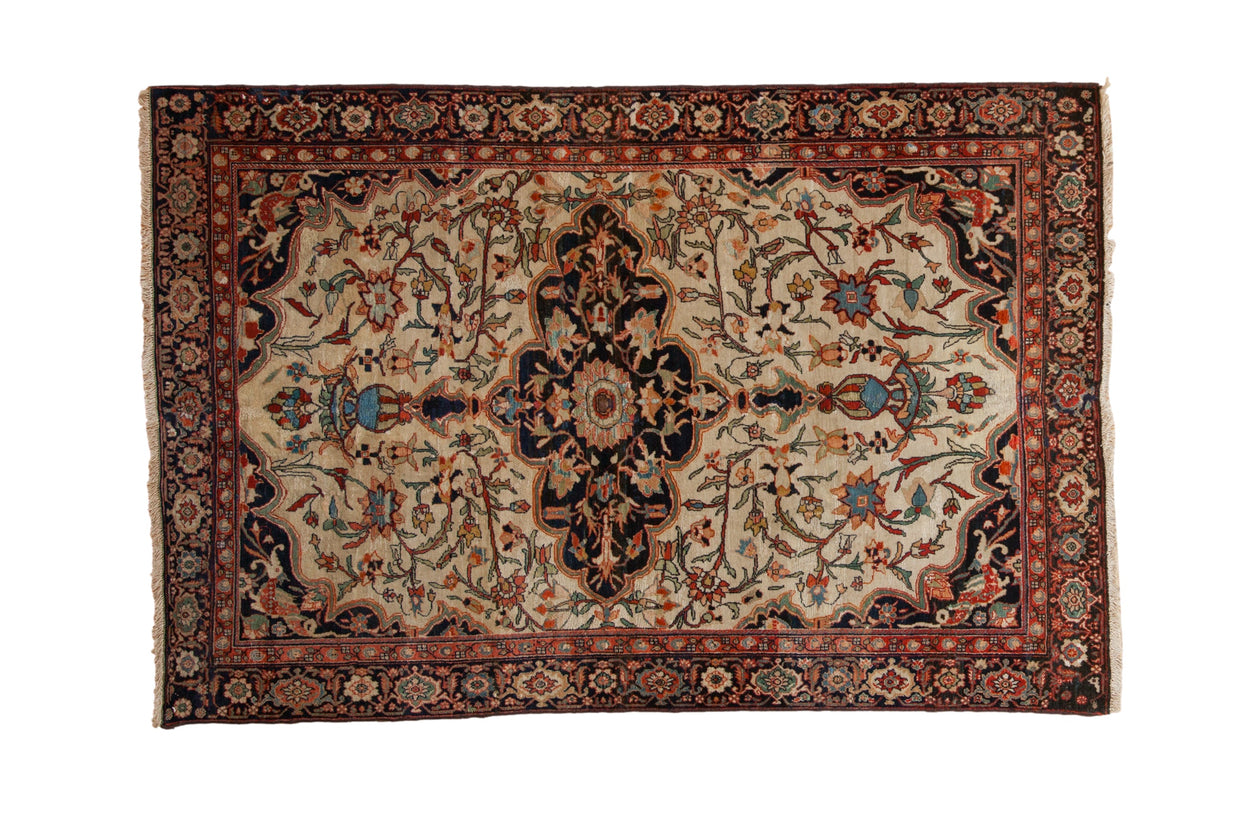 Finely woven antique Farahan Sarouk rug with a scalloped navy medallion over a densely patterned ivory field.
