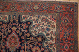 Intricate floral corner and madder red border of a hand-knotted antique Farahan Sarouk rug.