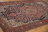 Angled view of the sprawling tree of life design and floral bouquets of an antique Farahan Sarouk.