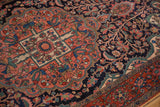 Scalloped medallion detail on an antique Farahan Sarouk with a dense, floral navy blue field.