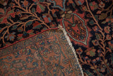 Lifted corner of an antique Persian rug revealing its hand-knotted foundation and red side cord.