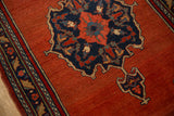 Detail of a vintage Bijar's navy medallion and border on a dense, brick-red hand-knotted pile.