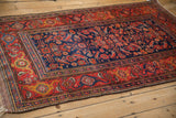 High-angle view of a Kurdish Hamadan rug's geometric Herati field and bold red samovar border.